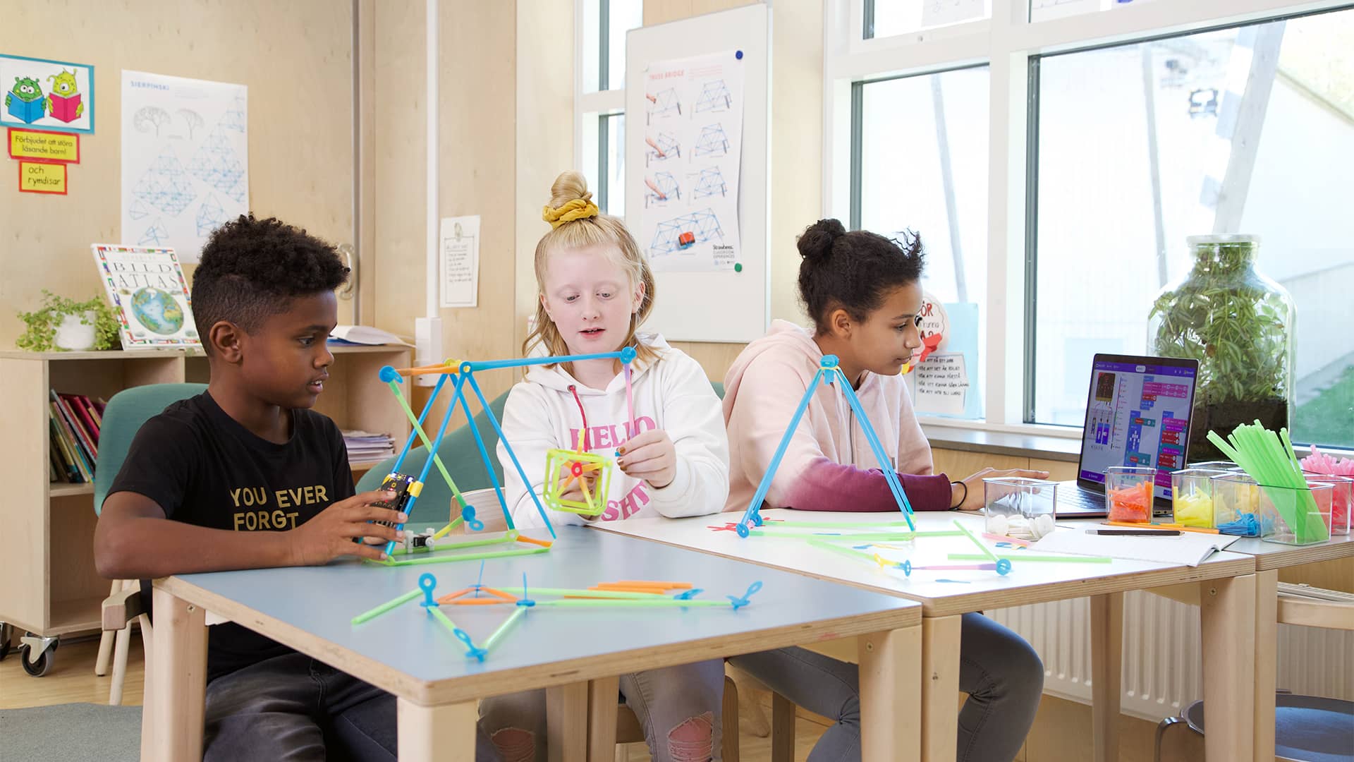 Creating a robotic crane in a group pair programming context amongst a mass of many project prototypes spread across desks.